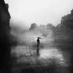 black and white photo of man with umbrella
