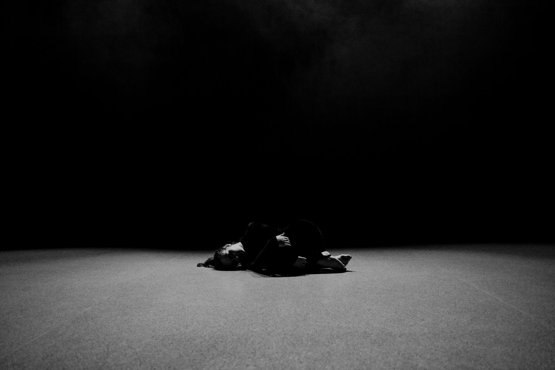 grayscale photo of man lying on ground