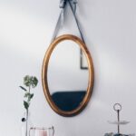 oval brown wooden framed hanging mirror