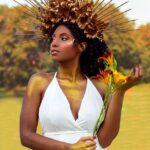 woman in white halter top holding sunflower