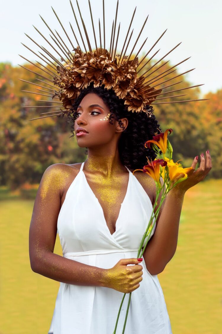 woman in white halter top holding sunflower